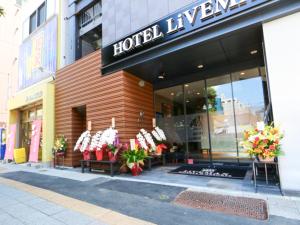 HOTEL LiVEMAX Asakusabashi-Eki Kitaguchi في طوكيو: متجر أمام الفندق مع الزهور في النافذة