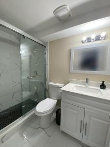 a bathroom with a shower and a toilet and a sink at Relaxing 3 Bedroom Basement Stay in Mississauga