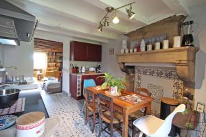 een keuken en een woonkamer met een tafel en een open haard bij Evasimone in Châteauponsac