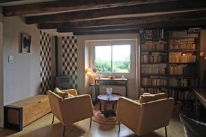 een woonkamer met een tafel en stoelen en een raam bij Evasimone in Châteauponsac