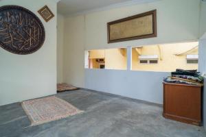 ein leeres Zimmer mit einem Teppich und einem Bild an der Wand in der Unterkunft Sabar Mansion 22 Mitra RedDoorz in Jakarta