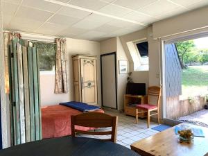 1 dormitorio con cama, mesa y ventana en Maison Pleumeur-Bodou, 1 pièce, 4 personnes - FR-1-368-395, en Pleumeur-Bodou