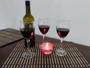 tre bicchieri di vino e una candela sul tavolo di Cabaña la Rivera a Nemocón