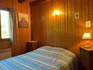 1 dormitorio con cama, lámpara y ventana en Chalet Samoëns, 5 pièces, 8 personnes - FR-1-624-134, en Samoëns