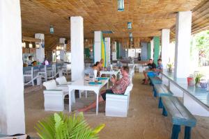 a group of people sitting at tables in a restaurant at Lime N Soda Beachfront Resort in Thongsala