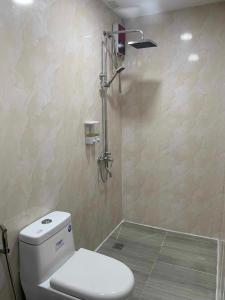 a bathroom with a toilet and a shower at Maine City Residences in Manila