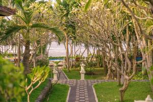 une passerelle traversant un parc arboré et l'océan dans l'établissement Coral Bay Bungalows Amed Bali, à Amed