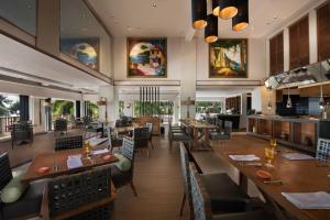 un ristorante con tavoli e sedie in legno e una tavola di Marriott's Phuket Beach Club a Mai Khao Beach