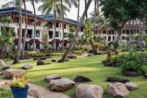un giardino di fronte a un edificio con rocce di Marriott's Phuket Beach Club a Mai Khao Beach