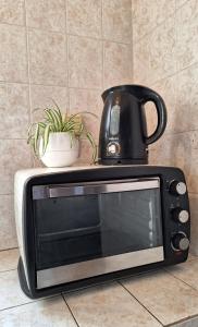 a microwave with a tea kettle on top of it at Departamento Vela Céntrico in Concepción