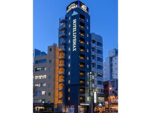 Un alto edificio blu con un cartello sopra di HOTEL LiVEMAX Asakusabashi-Ekimae a Tokyo