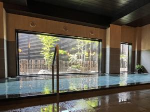 una piscina in un edificio con una grande finestra di ​Hotel Route-Inn Kumagaya​ a Kumagaya