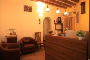 - un bar avec une chaise et un bureau dans la chambre dans l'établissement Le Clarisse Guest House, à Pondichéry