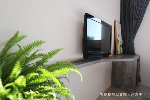 un televisor sentado en un estante en una pared en Talmud Hotel Gongyuan, en Taichung