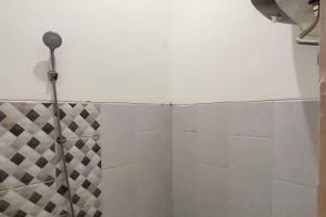 een douche met een douchegordijn in de badkamer bij Sukawana Guest House Mitra RedDoorz 