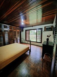 Hotel Jussara Cultural - Joinville في جوينفيل: غرفة نوم بسرير في غرفة بسقوف خشبية