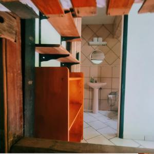 baño con puerta marrón y lavamanos en Hotel Jussara Cultural - Joinville en Joinville