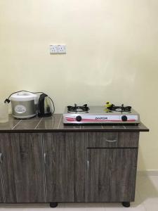 - un comptoir de cuisine avec une cuisinière et un appareil dans l'établissement Hajjah Homestay Asun, Jitra, Alor Setar Kedah, à Jitra 9 autres photos