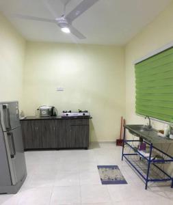 een keuken met een koelkast en een tafel. bij Hajjah Homestay Asun, Jitra, Alor Setar Kedah in Jitra