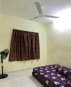 een slaapkamer met een bed en een plafondventilator bij Hajjah Homestay Asun, Jitra, Alor Setar Kedah in Jitra