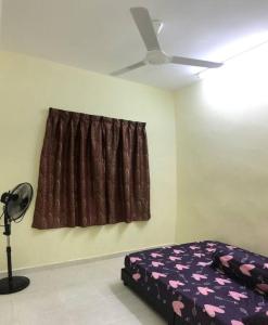 une chambre avec un lit et un ventilateur de plafond dans l'établissement Hajjah Homestay Asun, Jitra, Alor Setar Kedah, à Jitra