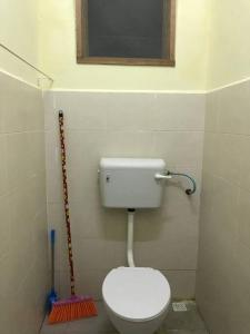 een kleine badkamer met een toilet en een bezem bij Hajjah Homestay Asun, Jitra, Alor Setar Kedah in Jitra