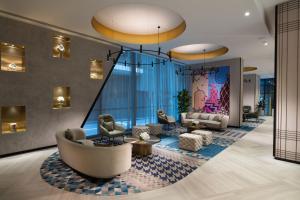 a lobby with couches and chairs and a large window at Dorsett Melbourne in Melbourne