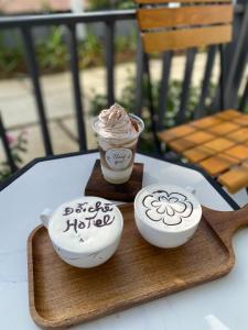 duas chávenas de café numa bandeja de madeira sobre uma mesa em Đồi Chè Hotel em Mộc Châu