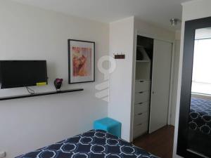 a bedroom with a bed and a tv on a wall at Temporal Apartment in Lima