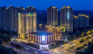 una ciudad iluminada por la noche con edificios altos en Holiday Inn Tianjin Wuqing, an IHG Hotel, en Wuqing