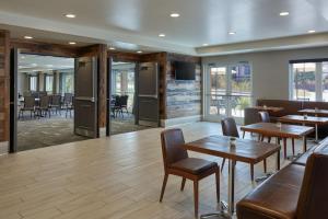 Residence Inn by Marriott Breckenridge في بريكنريدج: غرفة طعام مع طاولات وكراسي ونوافذ