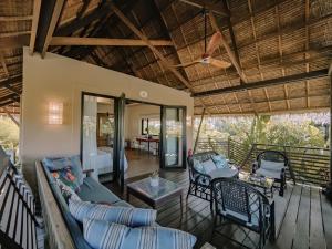 a living room with a couch and chairs on a deck at Kaimana Resort Siargao in General Luna