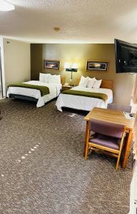 ein Hotelzimmer mit 2 Betten und einem Flachbild-TV in der Unterkunft Arlington Inn in Arlington