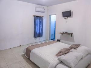 1 dormitorio con 1 cama grande y ventana azul en Rumah Ceria near Bandara Ahmad Yani Semarang RedPartner en Kalibanteng-lor