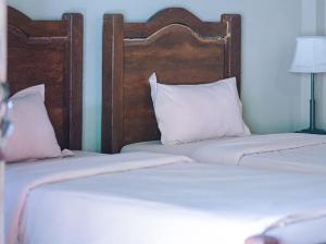 - 2 lits jumeaux avec des oreillers blancs dans une chambre dans l'établissement Rumah Dharma 2 Riverside, à Borobudur