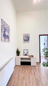 Sala de estar blanca con mesa y espejo en Kerepesi City Apartment en Budapest