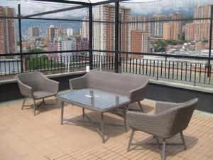 una mesa y sillas en un balcón con vistas en shared -compartido- apartment in a quiet, secure and lovely apartment, en Sabaneta