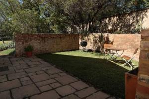 a backyard with a brick wall and a table and chair at Gorgeous 1-bedroom Sandton flat in Johannesburg