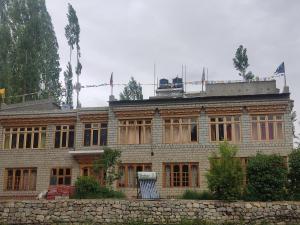 a large brick building with boarded up windows at Streamlet homestay in Leh