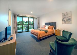 a bedroom with a bed and a television and a balcony at Summerhouse Pet Friendly at Surf Beach in Surf Beach