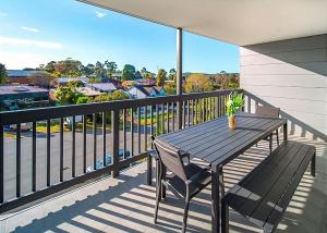 a table and chair on a balcony with a view at Summerhouse Pet Friendly at Surf Beach in Surf Beach