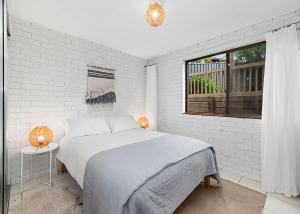 a white bedroom with a bed and a window at Park and Relax managed by Batemans Bay Accom in Surf Beach +10 photos
