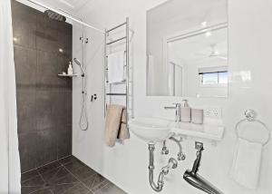 a white bathroom with a sink and a shower at Cloud 9 at Batehaven in Batehaven +10 photos
