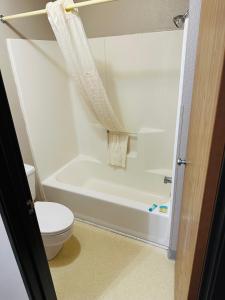 a bathroom with a toilet and a white bath tub at Arlington Inn in Arlington