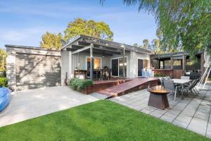 un patio trasero con terraza y una casa en Tomaga Tides, en Mossy Point