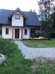 a white house with a gravel driveway at Domek w Zaciszu in Szaflary