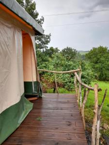 a tent with a wooden walkway in a field at Maison Dougnac La Bohéme in Fleurance