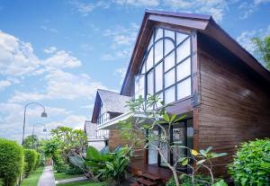 a house with a large window on the side of it at Villa Atra Bambulogy by Nagisa Bali in Kerobokan