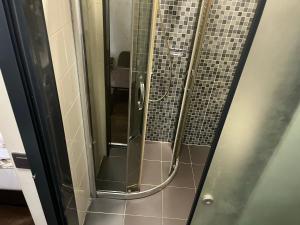 La salle de bains est pourvue d'une douche avec des portes en verre. dans l'établissement Pandora Hotel, à Istanbul