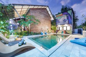 a house with a swimming pool in the yard at Villa Atra Bambulogy by Nagisa Bali in Kerobokan